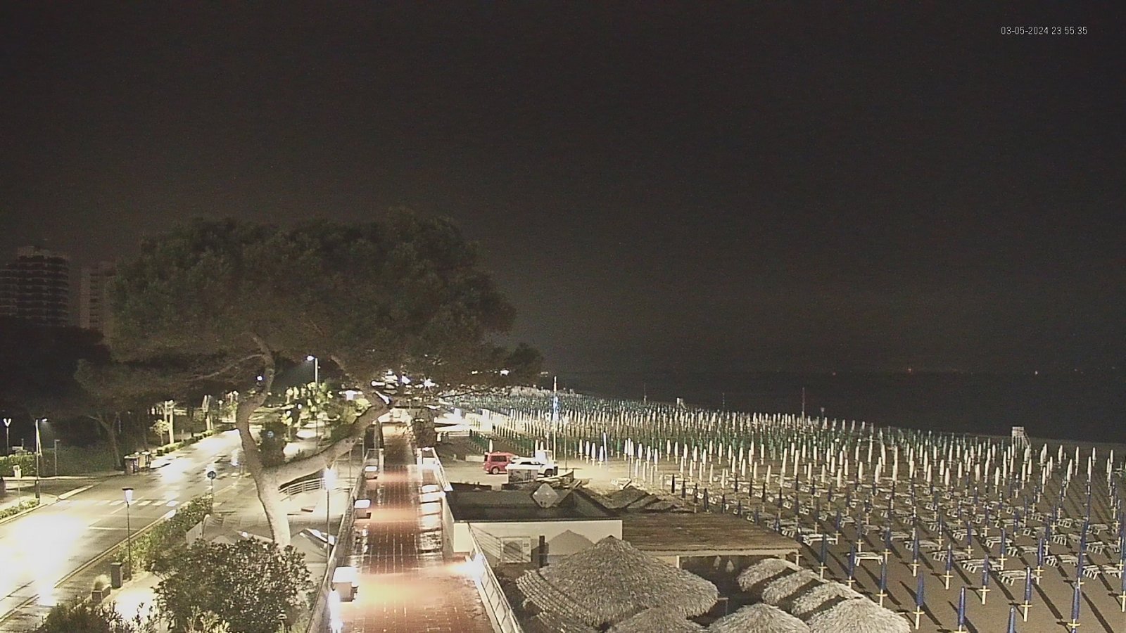 Webcam image with view of the beach and umbrellas on northeast